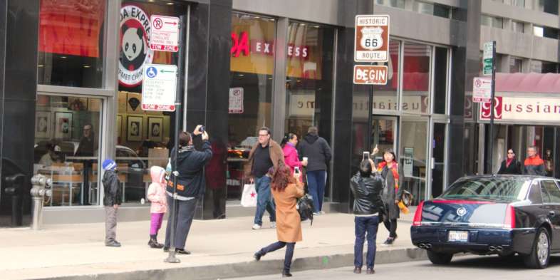 Turistas em volta da placa da Rota 66 em Chicago