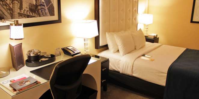 Mesa de trabalho e cama do quarto do hotel Warwick Allerton em Chicago