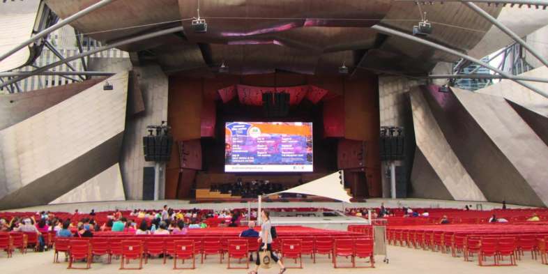 Programação do festival na tela e muito espaço para sentar antes de começar a exibição do filme no Summer Film Fest no Millennium Park em Chicago