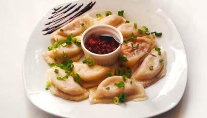 Maria Escaleira - Pierogis recheados com carne seca e requeijão, cobertos com molho e com acompanhamento de bacon - Capa