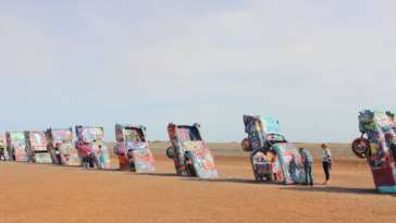 A longa fileira de carros grafitados e enterrados no chão do Cadillac Ranch em Amarillo, Texas
