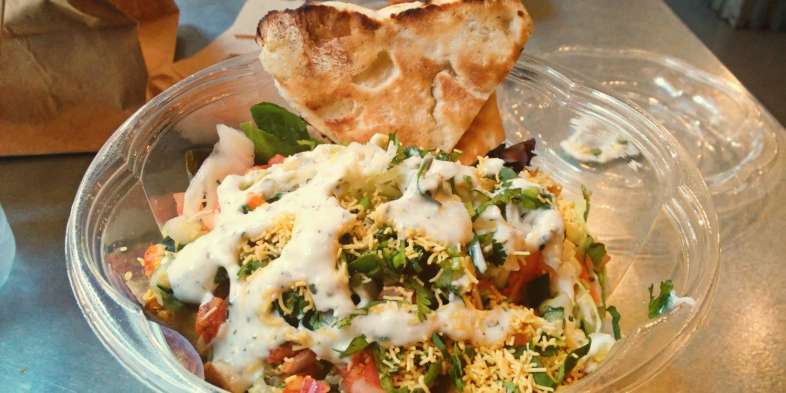 O prato com base de salada do Naansense, casa de comida indiana rápida de Chicago O prato com base de salada do Naansense, casa de comida indiana rápida de Chicago