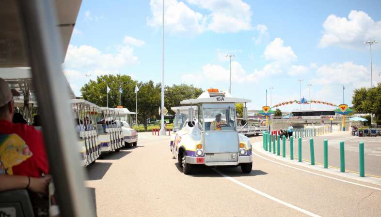 Devido ao tamanho do estacionamento, um trem sobre rodas leva os visitantes até a balsa do Magic Kingdom Devido ao tamanho do estacionamento, um trem sobre rodas leva os visitantes até a balsa do Magic Kingdom