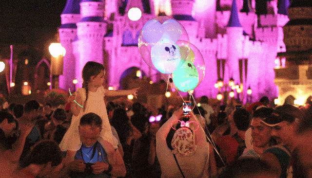 Criança querendo pegar balão no parque Magic Kingdom da Disney Enquanto não tem fogos, quero balão!