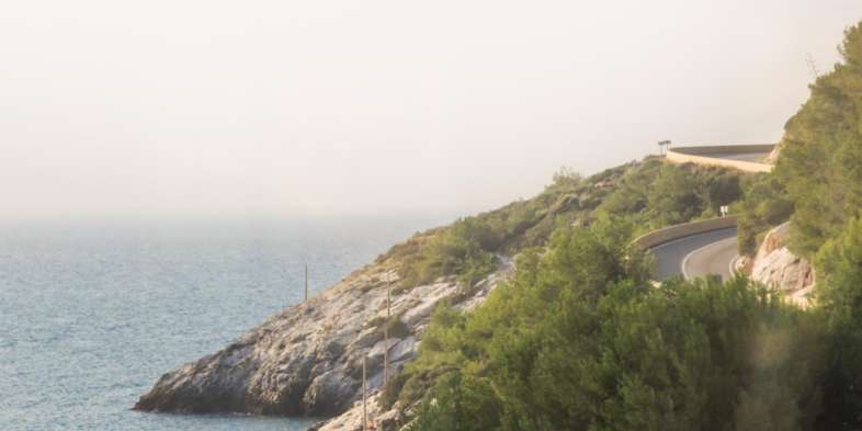 O caminho até o PortAventura é repleto de belas paisagens da costa da Espanha Encosta rochosa e mar vistos do trem em Tarragona a caminho do PortAventura