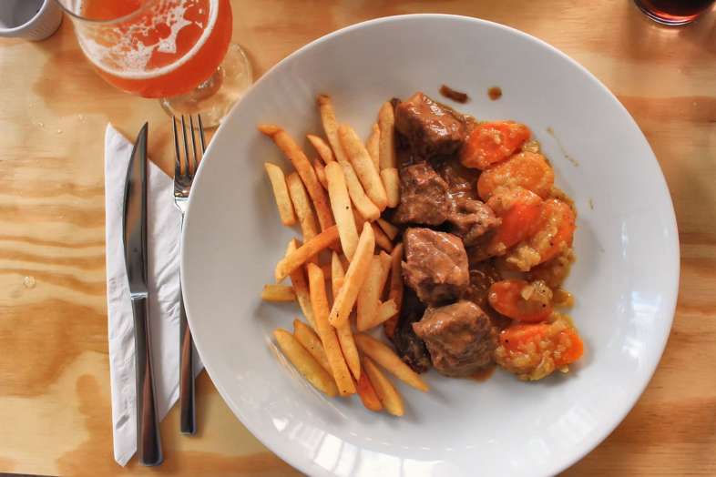 Vlaamse stoofvlees (carne assada em cerveja escura), acompanhado de cenouras e batatas fritas Vlaamse stoofvlees (carne assada em cerveja escura), acompanhado de cenouras e batatas fritas